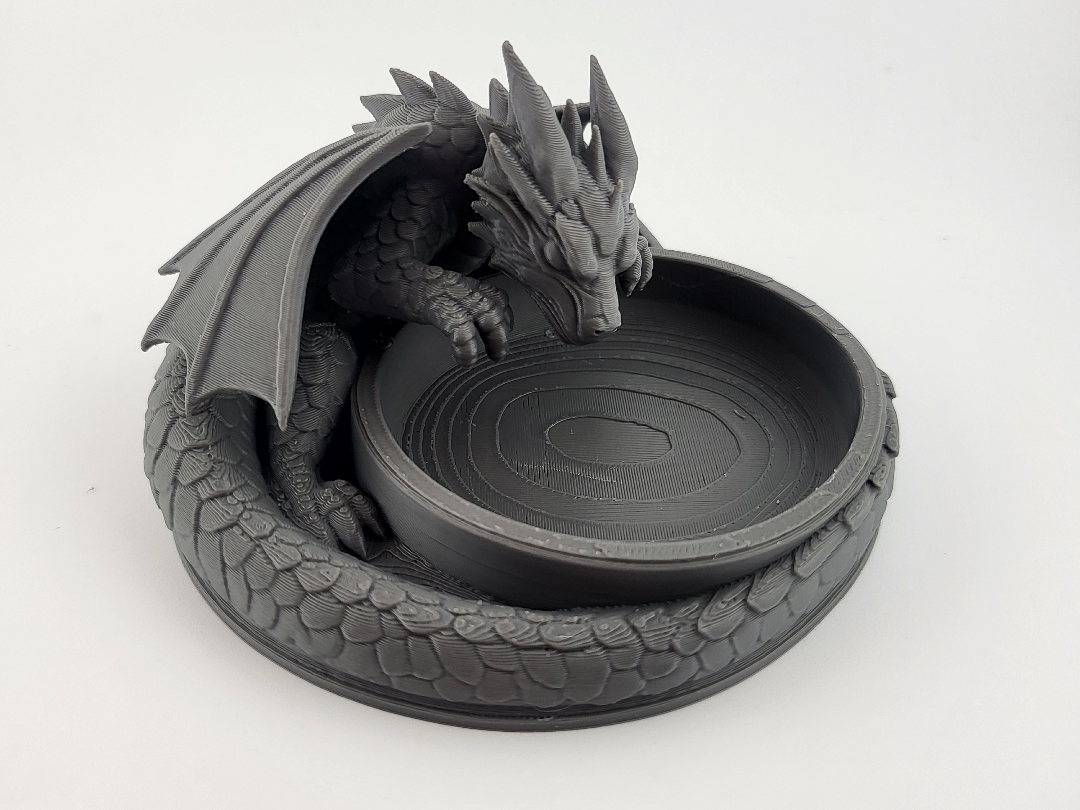 Vaciabolsillos impreso en 3D presentado desde un lado con compartimentos visibles y un fondo neutro