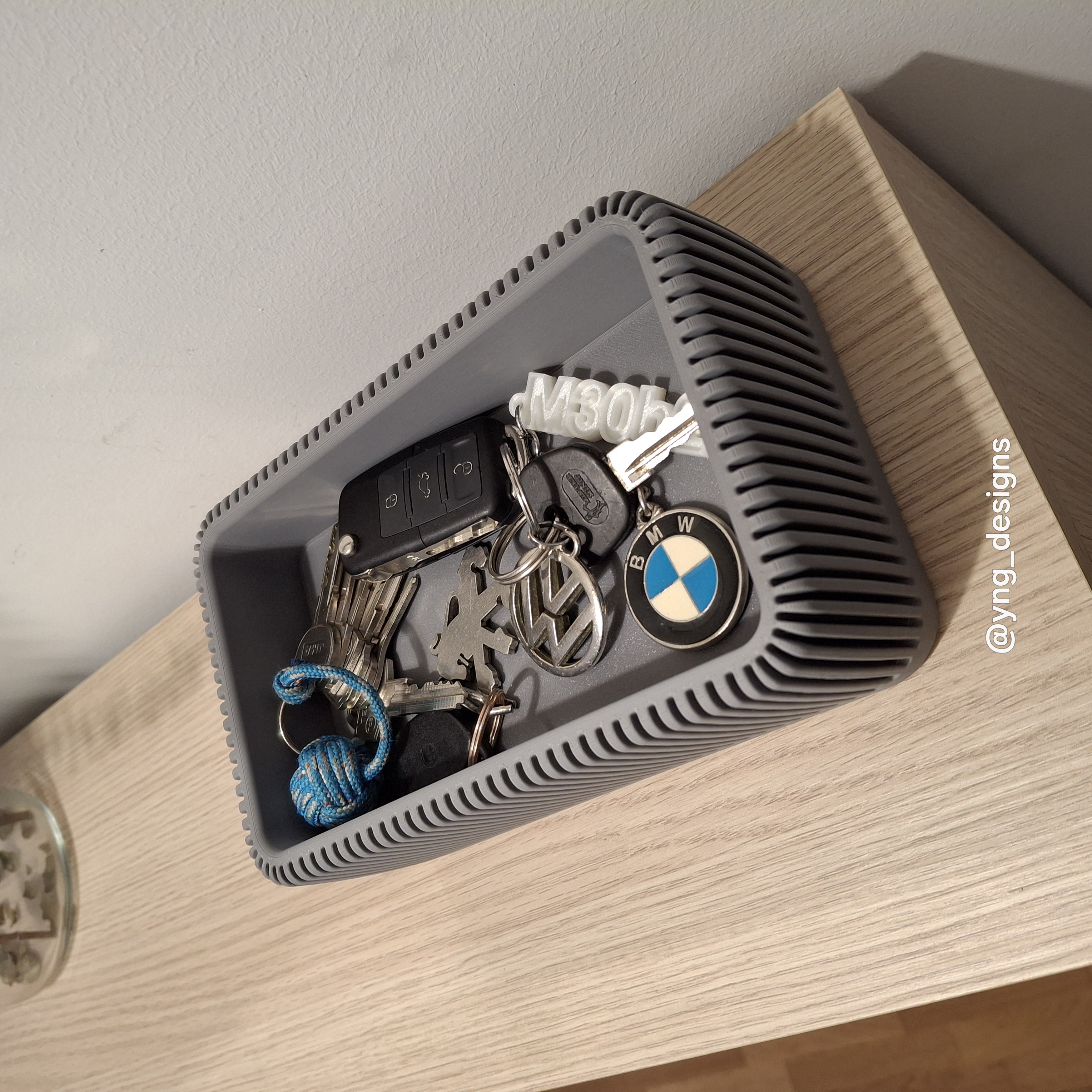 Vaciabolsillos impreso en 3D con compartimentos organizadores sobre una mesa clara